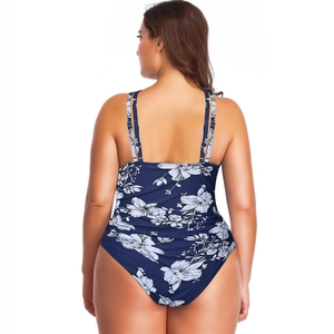 Detail view of navy blue plus size one-piece swimsuit with white floral print and U-back design