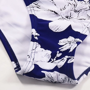 Macro shot of swimsuit seam showing double-needle stitching and floral fabric detail