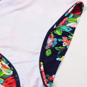 Macro detail of high-quality double-needle stitching on floral trim white swimwear