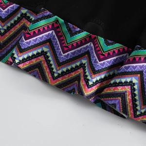 Macro detail of breathable black mesh fabric and vibrant zigzag geometric print swimwear