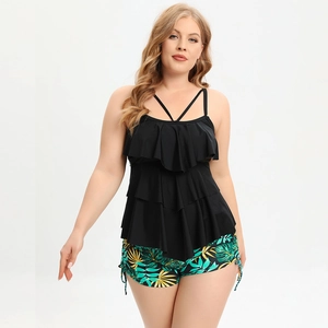 Detail of plus size tankini with layered black ruffles and tropical leaf print swim shorts