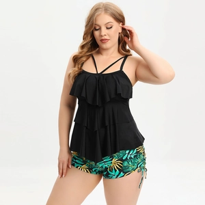Detail of plus size tankini featuring black ruffled top and tropical leaf print swim shorts