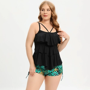 Detail of plus size tankini with black tiered ruffles and tropical leaf print shorts