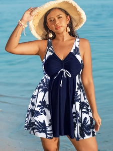 Robe de bain grande taille bleu marine avec imprimé cocotier sur une plage tropicale