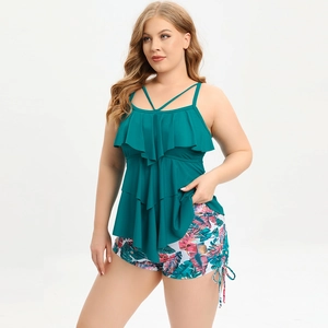 Detail of plus size tankini with green ruffle top and floral tropical print bottoms