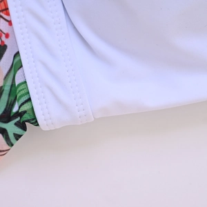 Close-up of high-elasticity fabric with tropical print and reinforced flatlock stitching