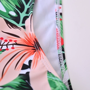 Detail of tropical floral print swimwear fabric with white mesh lining and double stitching