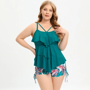 Detail of plus size tankini with peacock blue ruffles and tropical leaf print swim shorts