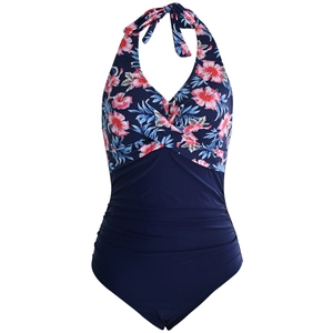 Detail of floral print halter top and ruched tummy control one-piece swimsuit