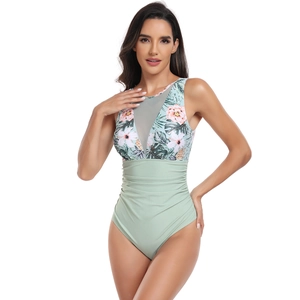 Détail d'un maillot de bain une pièce avec imprimé floral, décolleté mesh et fronces gainantes