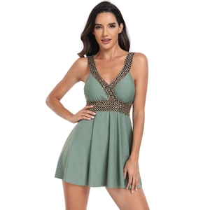 Détail d'un maillot de bain robe à col en V avec bordure tressée noir et or vert