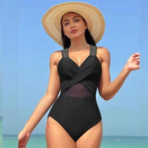Détail d'un maillot de bain noir une pièce avec empiècements en résille et bretelles