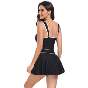 Detail view of black one-piece swimdress with white trim and athletic pleated skirt