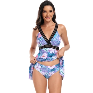 Détail d'un tankini imprimé tropical violet avec mesh noir et décolleté en V profond