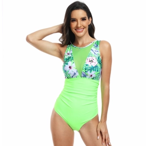 Détail du maillot de bain à fleurs et vert fluo avec décolleté en mesh et fronces