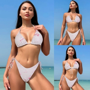 Detailed close-up of white bikini with pink marble texture and adjustable side ties