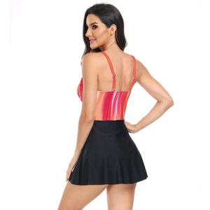 Vista laterale del costume da bagno due pezzi con top a righe e gonna nera a pieghe