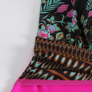 Détail macro du maillot de bain floral avec bordure géométrique et coutures roses