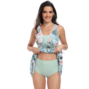Women's two-piece tankini swimsuit with tropical floral print top and high-waisted mint bottom