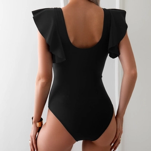 Detail of black one-piece swimsuit featuring ruffled shoulders and a deep U-shaped back design
