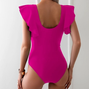 Detail of rose red one-piece swimsuit featuring ruffled shoulder straps and an open back