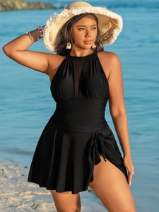 Detail of plus size black swimdress featuring mesh halter neck and ruched waistline