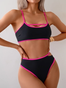 Detail of a black bikini set with neon pink trim and cutout strap design on top