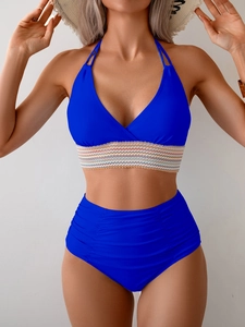 Detail of royal blue halter bikini top with colorful wavy band and high-waisted ruched bottom