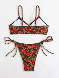 Flat lay of leopard and cherry print bikini with side-tie bottoms on white background