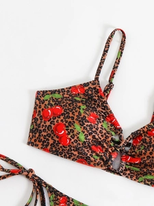 Close-up of leopard print and cherry pattern fabric on the bikini top with thin straps