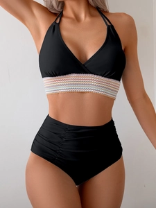 Detail of black bikini with halter neck and colorful wave pattern ribbon on the bust