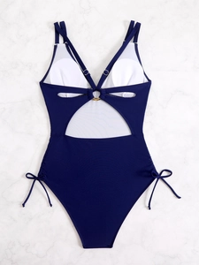Dettaglio costume intero blu scuro con schiena scoperta, anelli metallici e spalline