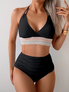 Detail of black bikini top featuring colorful striped elastic band and halter neck design