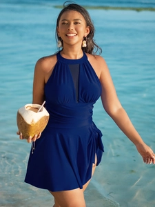 Detail of navy blue plus size swimsuit featuring mesh V-neckline and side tie bow on the beach