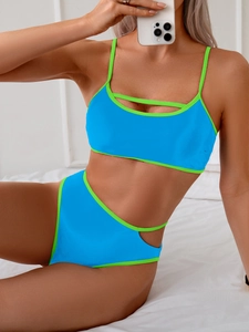 Detail of blue bikini top with neon green piping and stylish chest cutout