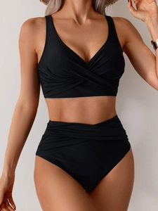 Detail of high waisted black bikini with tummy control ruching and V-neck twist front knot