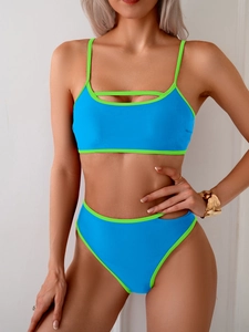 Detail of bright blue bikini set with lime green piping and trendy side cut-out design