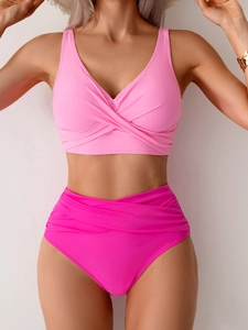 Detail of high waisted bikini bottoms with ruched cross waist design in rose pink