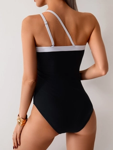 Women's backless one-piece swimsuit in black and white with unique asymmetric straps