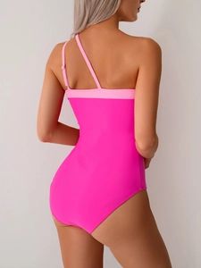 Rear view of vibrant hot pink one-piece swimsuit with asymmetrical back straps detail