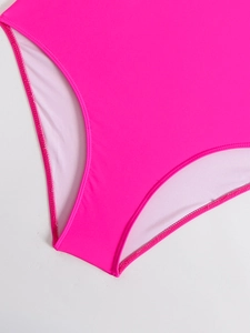 Close-up of fluorescent pink one-piece swimwear featuring elastic fabric and neat stitching