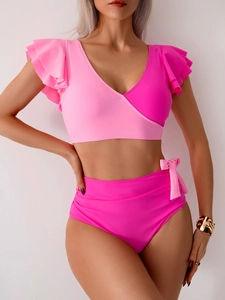 Detail of color-block bikini set with pink ruffled top and high-waisted bottoms with bow