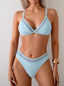 Detail of light blue bikini featuring mesh splicing and triangular cup design on model