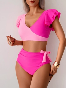 Detail view of high waist bikini bottoms with pink side tie bows and ruffled sleeves top