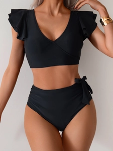Detail of black bikini set featuring ruffled sleeves and high-waisted bow tie swim bottom