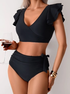 Close-up of black high-waisted bikini with ruffled sleeves and side bow details