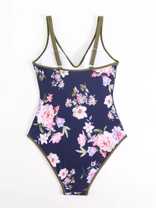 Detail showing adjustable olive straps and floral print on navy one-piece swimsuit