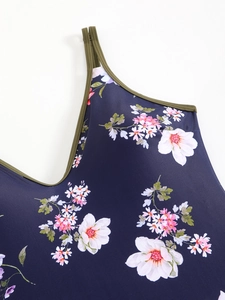 Detail of floral one-piece swimsuit with navy print and contrast olive green straps