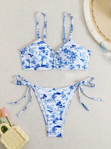 Flat lay of blue and white Toile de Jouy print bikini set with stylish vacation accessories