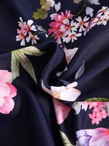 Detail of floral print on navy blue synthetic swimwear fabric with soft texture